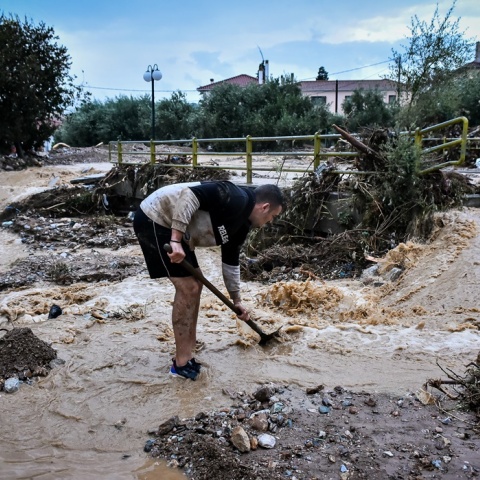 Κάτοικος του Βόλου επιχειρεί να βγάλει τη λάσπη από σημείο της πόλης