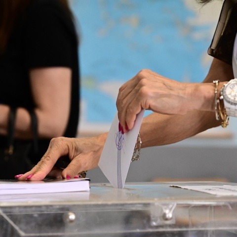 Χέρι γυναίκας ρίχνει ψηφοδέλτιο σε κάλπη