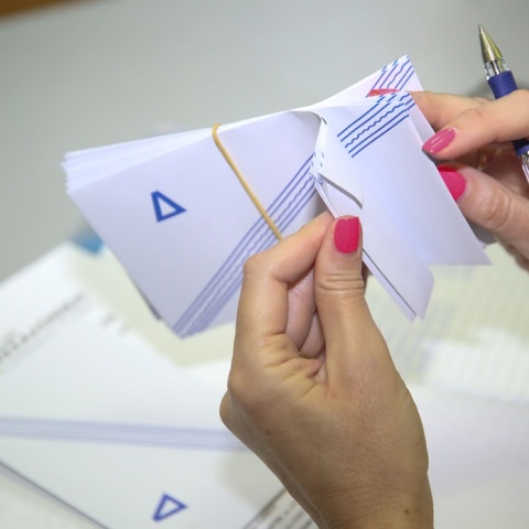 Γυναίκα κρατά στα χέρια της φακέλους για τα ψηφοδέλτια των Δημοτικών Εκλογών