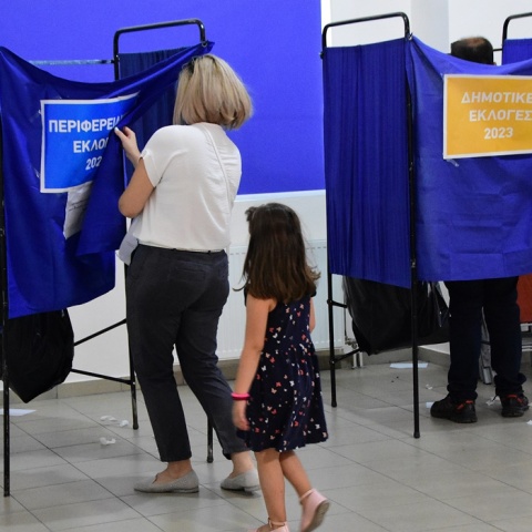 Κοριτσάκι μαζί με τη μητέρα του μπαίνει σε παραβάν για να ψηφίσει στις Δημοτικές και Περιφερειακές Εκλογές 2023