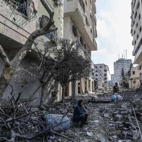 Γυναίκα κάθεται σε χαλάσματα σε πόλη του Ισραήλ