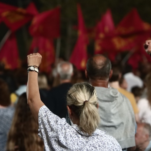 Υψωμένες αριστερές γροθιές από μέλη του ΚΚΕ και σημαίες του κόμματος