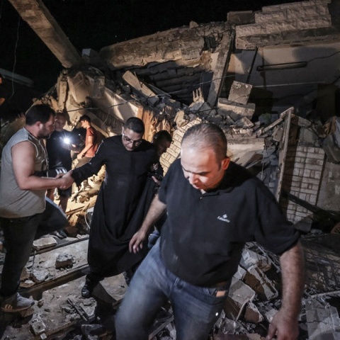 Ιερέας και πολίτες κοντά στο σημείο του βομβαρδισμού της ελληνορθόδοξης εκκλησίας στη Γάζα