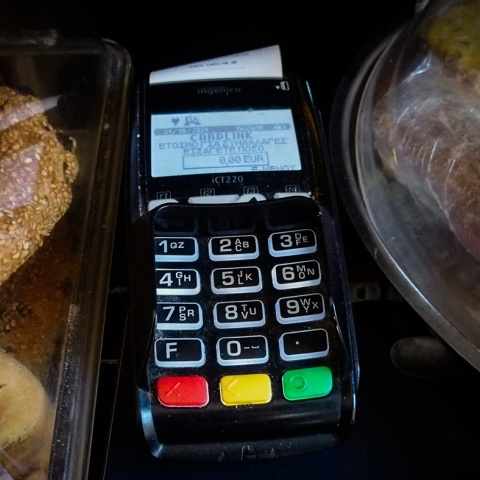Μηχάνημα POS για τις τραπεζικές συναλλαγές δίπλα σε αρτοσκευάσματα