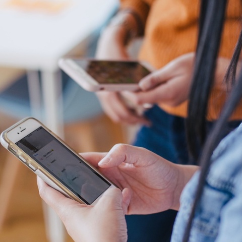 Δύο νεαρές κοπέλες ασχολούνται από τα κινητά τους