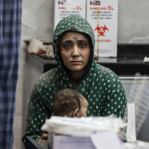 Μητέρα με την απόγνωση ζωγραφισμένη στο πρόσωπό της κοιτά τον φακό και κρατά στην αγκαλιά της το μωρό της μέσα στο νοσοκομείο Αλ Σίφα στη Γάζα