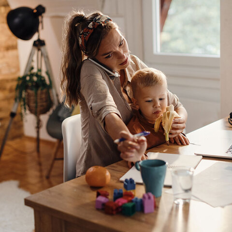 Γυναίκα μιλάει στο τηλέφωνο και κρατάει παιδί