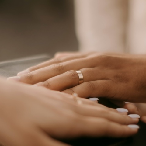 Χέρι γαμπρού και νύφης με τις βέρες