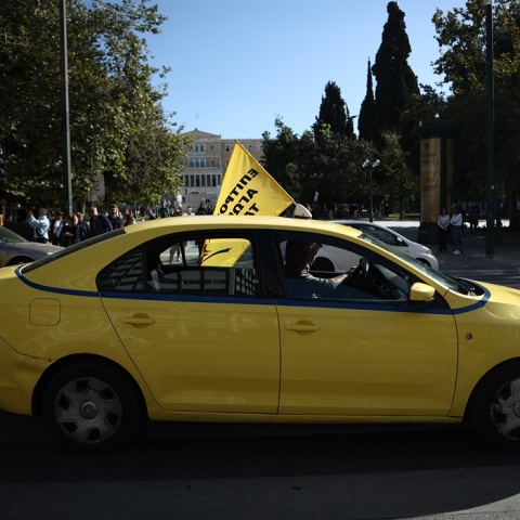 Απεργία ταξί: Οδηγός στο κέντρο της Αθήνας με σημαία κατά τη διάρκεια απεργίας
