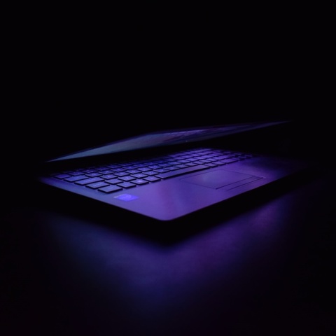 Λάπτοπ σε σκοτεινό δωμάτιο το οποίο φωτίζει μόνο η αναμμένη οθόνη