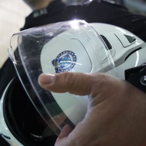 Αστυνομικός της ΕΛ.ΑΣ κρατάει το κράνος του