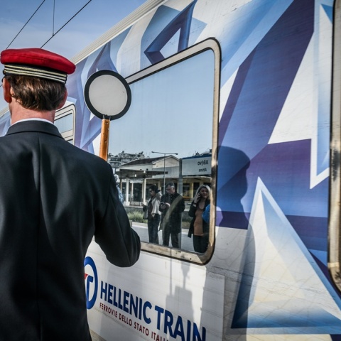 Αναχώρηση τρένου από σταθμό και σταθμάρχης που δίνει το σήμα εκκίνησης