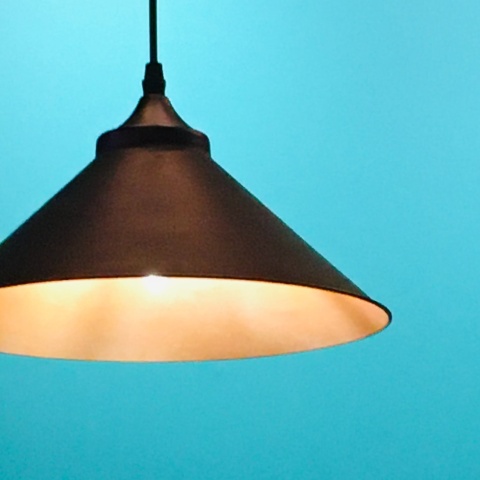 Λάμπα που κρέμεται μέσα σε φωτιστικό από το ταβάνι σε μπλε φόντο