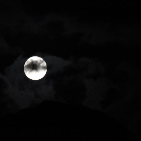 Η πανσέληνος Δεκεμβρίου πίσω από σύννεφα στον χριστουγεννιάτικο ουρανό 