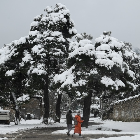 Πολίτες περπατούν στο χειμωνιάτικο τοπίο εν μέσω χιονιά