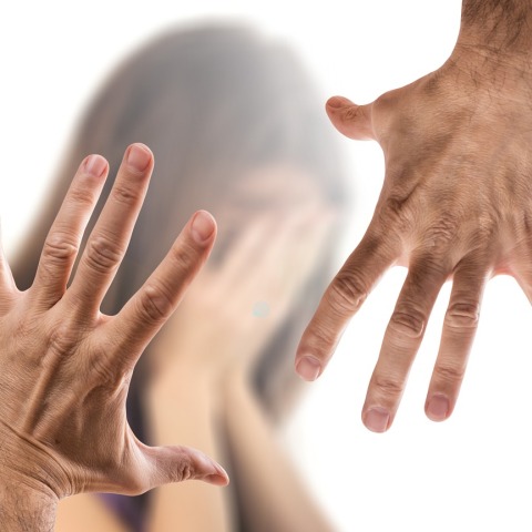 Χέρια που απειλούν γυναίκα η οποία προσπαθεί να προφυλαχθεί