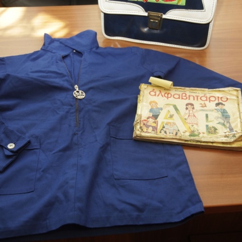 Μπλε ποδιά δίπλα με το αλφαβητάριο