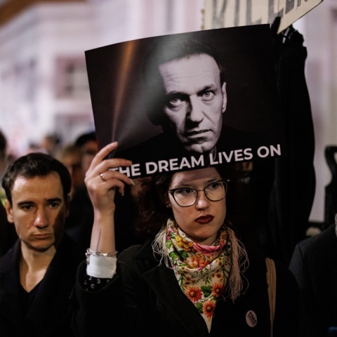 Διαδηλώτρια κρατά φωτογραφία του Αλεξέι Ναβάλνι στην οποία γράφει «The Dream Lives On»