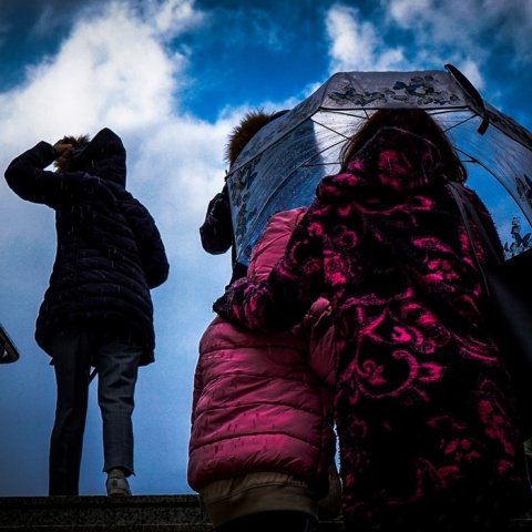 Γυναίκα με ομπρέλα προστατεύεται από ισχυρή βροχόπτωση