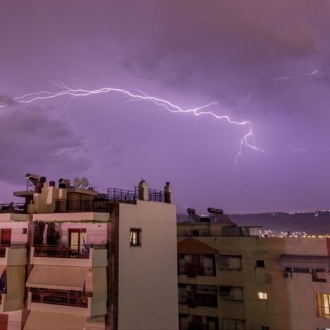 Κεραυνοί στον ουρανό πάνω από πολυκατοικίες