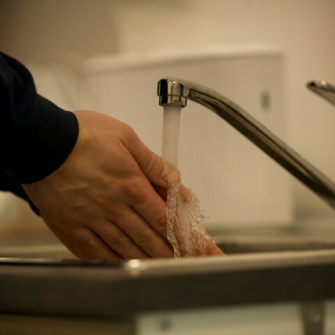 Άτομο που πλένει τα χέρια του κάτω από τη βρύση