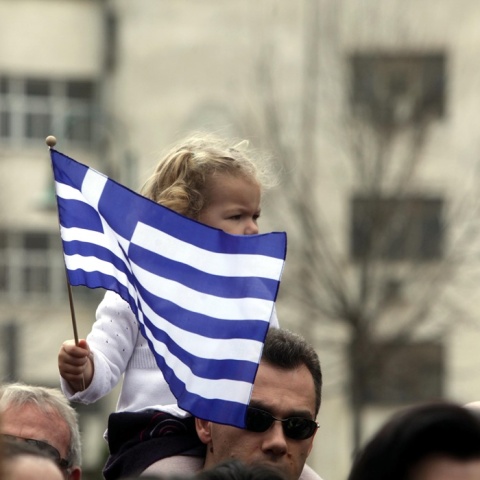 Παιδάκι με την ελληνική σημαία στους ώμους του πατέρα του