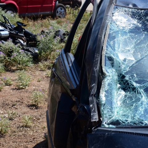 Μηχανή πεσμένη σε χωράφι και τα σημάδια στο παμπρίζ αυτοκινήτου μετά τη σύγκρουση σε αυτοκίνητο