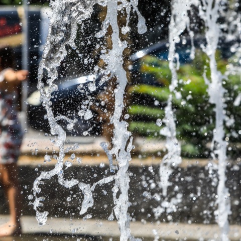 Άτομο δίπλα από συντριβάνι εν μέσω υψηλών θερμοκρασιών