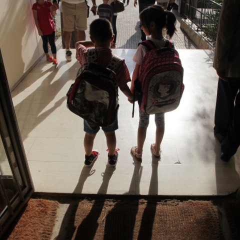 Παιδάκια πιασμένα χέρι χέρι μπαίνουν στο σχολείο τους με τις τσάντες στους ώμους