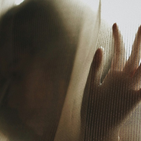 Γυναίκα πίσω από την κουρτίνα