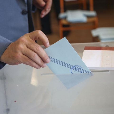 Γαλάζιο φακελάκι και χέρι που το ρίχνει στην κάλπη των Ευρωεκλογών