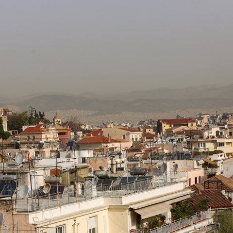 Η αφρικανική σκόνη δεν επιτρέπει να δούμε τον ορίζοντα πάνω από τις ταράτσες των κτιρίων στην Αττική