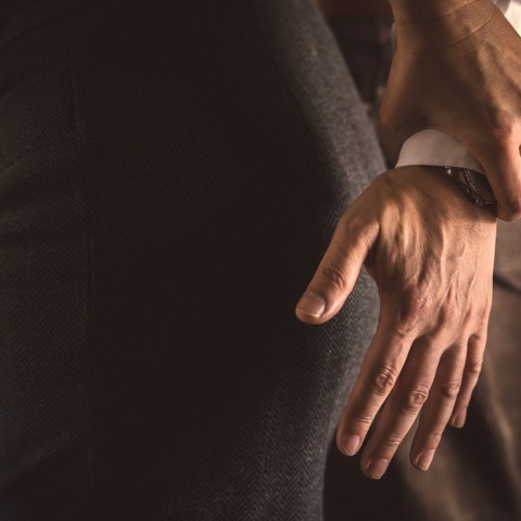 Χέρι άνδρα επιδιώκει να πιάσει τα οπίσθια γυναίκας, με το χέρι της να το απομακρύνει