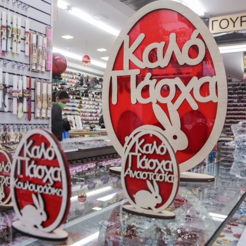 Διακοσμητικά που γράφουν «Καλό Πάσχα» σε κατάστημα με λαμπάδες και άλλα πασχαλινά προϊόντα