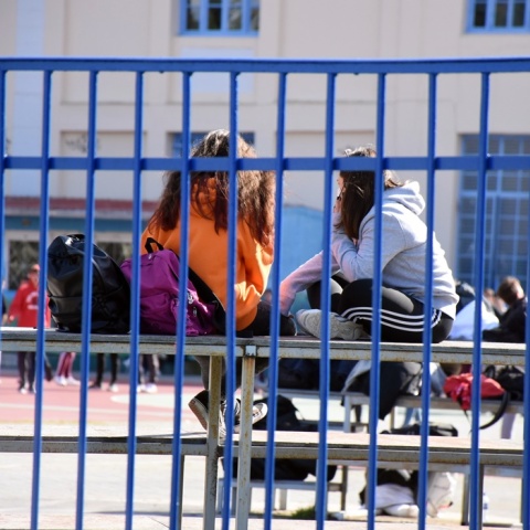 Μαθητές κάθονται σε σιδερένια κερκίδα στο προαύλιο σχολείου