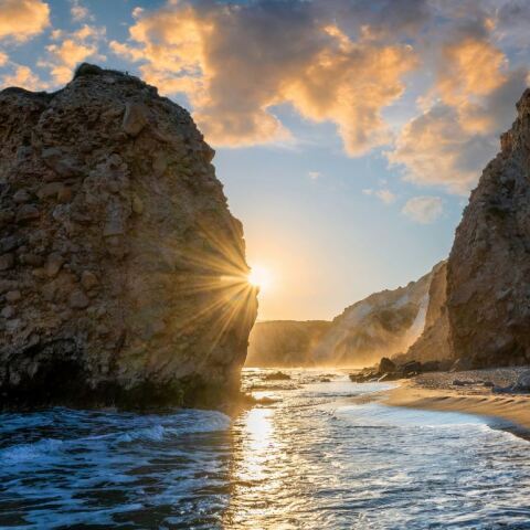 Ηλιοβασίλεμα ανάμεσα σε δύο βράχους σε παραλία της Μήλου