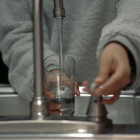 Γυναίκα βάζει νερό σε βρύση