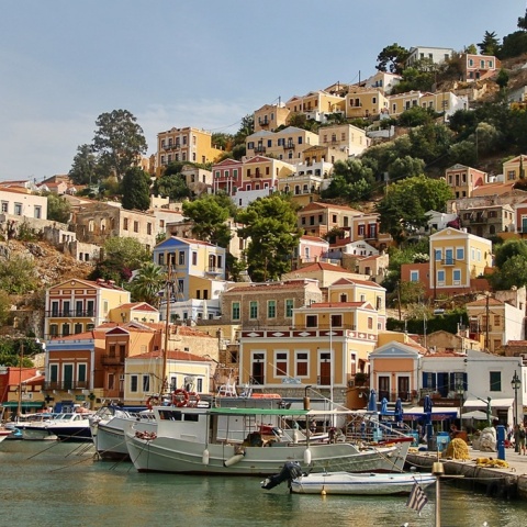 Φωτογραφία από τη Σύμη - Καϊκια δεμένα στην προβλήτα και πίσω τα πολύχρωμα σπίτια του νησιού