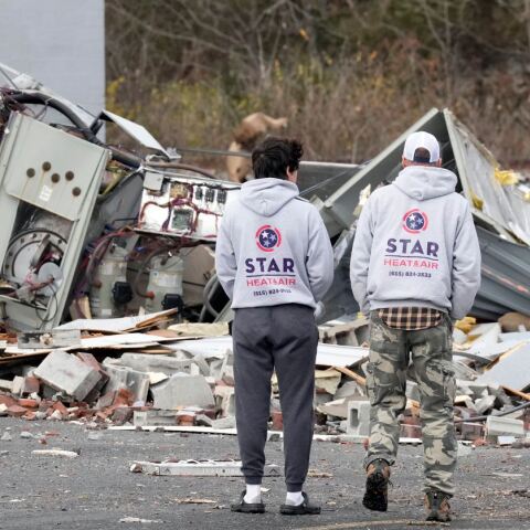 Δύο άνθρωποι ανάμεσα σε χαλάσματα που άφησε πίσω ανεμοστρόβιλος στις ΗΠΑ