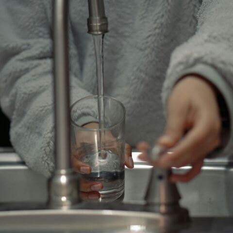 Γυναίκα βάζει νερό σε βρύση