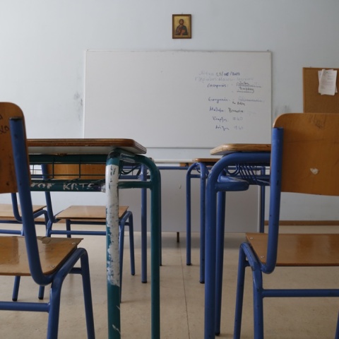 Σχολική αίθουσα άδεια από παιδιά με θρανία και καρέκλες και επίκεντρο στο βάθος της φωτογραφίας τον πίνακα