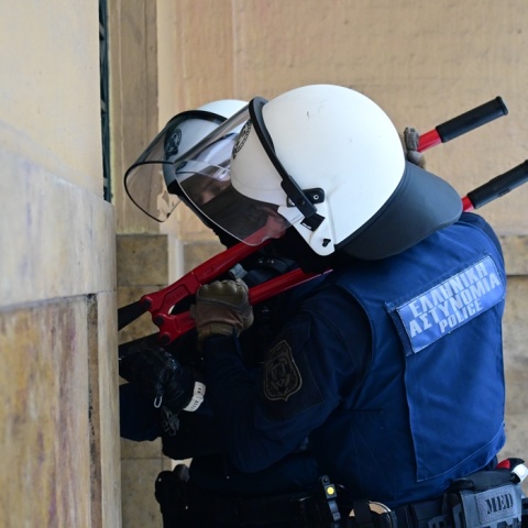 Αστυνομικοί με κόφτη στα χέρια επιχειρούν να κόψουν την αλυσίδα σε πύλη της Νομικής Σχολής Αθηνών