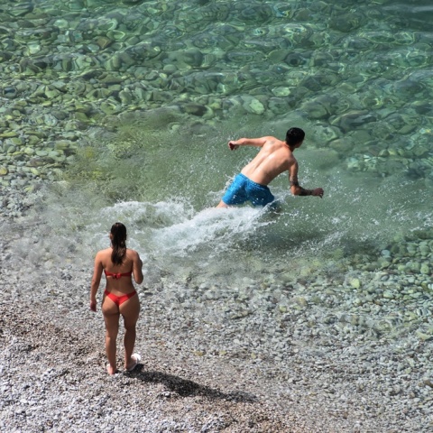 Άτομα σε παραλία ετοιμάζονται για βουτιά στη θάλασσα