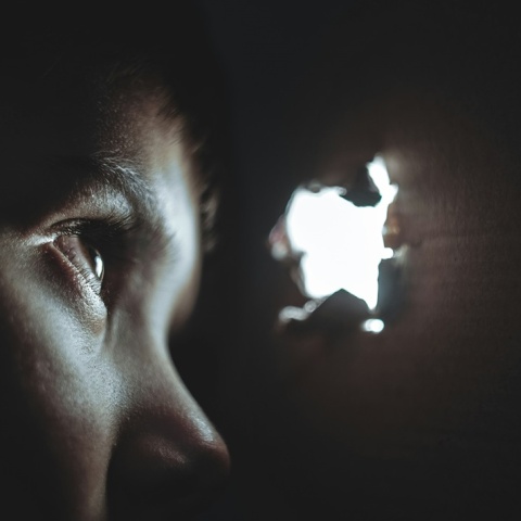 Παιδί που κοιτά μέσα από τρύπα σε κούτα