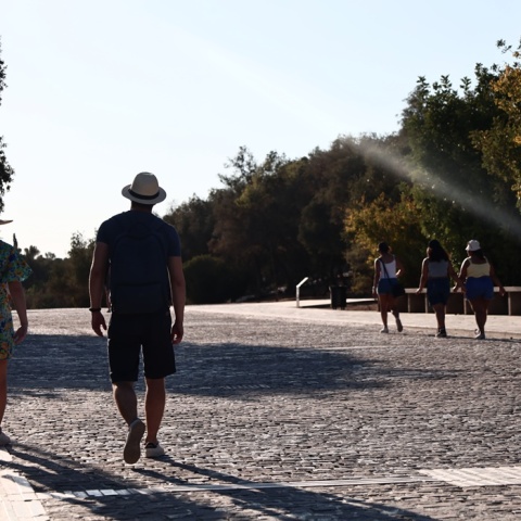 Πολίτες με καπέλο περπατούν στη Διονυσίου Αρεοπαγίτου υπό υψηλές θερμοκρασίες
