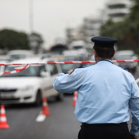 Τροχονόμος με κορδέλα της αστυνομίας έχει αποκλείσει σημείο και ρυθμίζει την κυκλοφορία