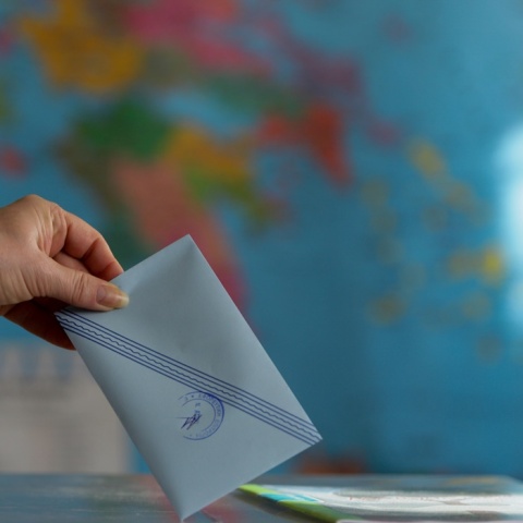 Χέρι ρίχνει τον φάκελο με το ψηφοδέλτιο στην κάλπη