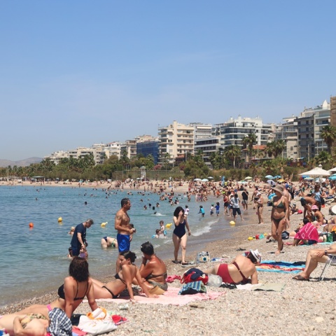 Λουόμενοι απολαμβάνουν στιγμές δροσιάς σε παραλία στην Αττική