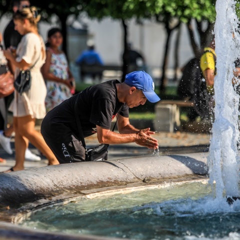 Πολίτης δροσίζεται βουτώντας τα χέρια του στο νερό του σιντριβανιού στο Σύνταγμα