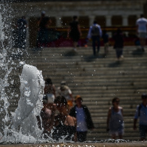 Συντριβάνι στο Σύνταγμα και πίσω πολίτες που περπατούν υπό ζέστη